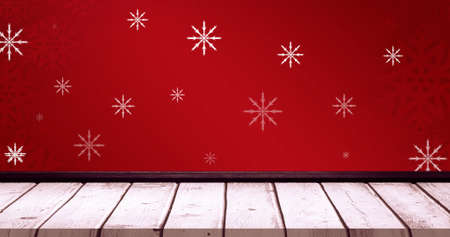 Image of falling snowflakes on red background and wooden floor. christmas, tradition and celebration...