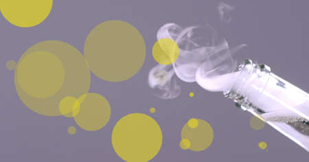 Image of glowing yellow spots falling over champagne cork exploding from bottle. new year's party, christmas, tradition and celebration concept digitally generated image.の写真素材