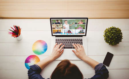 Overhead view of businesswoman using laptop at her deskの写真素材