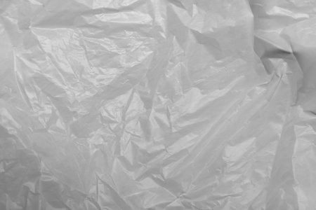Reflecting light and shadow on creases and folds in thin white plastic sheeting. monochrome light and texture, abstract background image.の写真素材
