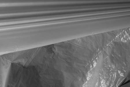 Lines of reflecting light and shadow on pleats and creases in plastic sheeting. monochrome light and texture, abstract background image.の写真素材