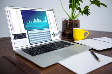 Laptop on desk with statistical data on screen. business communication and digital interface technology digital composite image.の写真素材