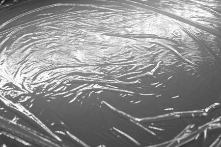 Reflecting light and shadow on creases and folds in plastic sheeting. monochrome light and texture, abstract background image.の写真素材