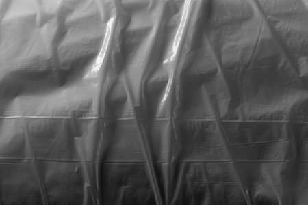 Reflecting light and shadow on creases and folds in plastic sheeting. monochrome light and texture, abstract background image.の写真素材