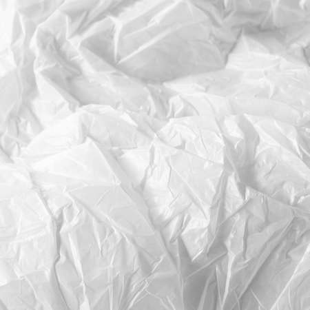 Reflecting light and shadow on creases and folds in scrunched white fabric or plastic sheet. monochrome light and texture, abstract background image.の写真素材