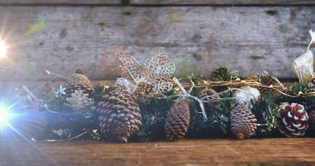 Composition of light over christmas decorations with pine cones. christmas, tradition and celebration concept digitally generated image.の写真素材