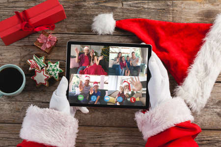 Santa claus on christmas laptop video call with diverse group of friends. christmas, festivity and communication technology.の写真素材
