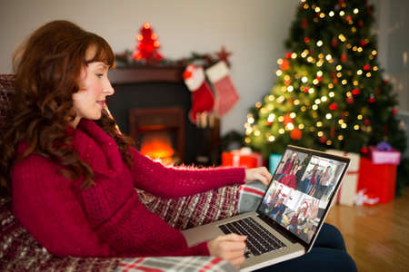 Content redhead using laptop at christmas at home in the living room