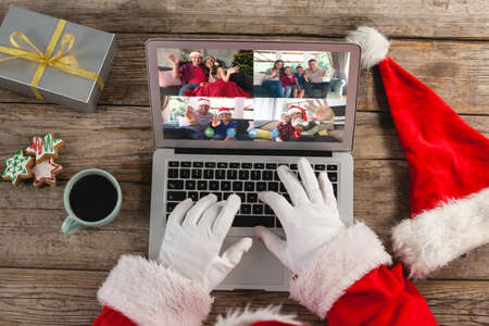 Santa claus on christmas laptop video call with diverse group of friends. christmas, festivity and communication technology.の写真素材