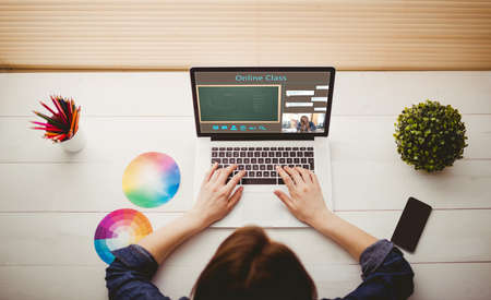Overhead view of businesswoman using laptop at her deskの写真素材