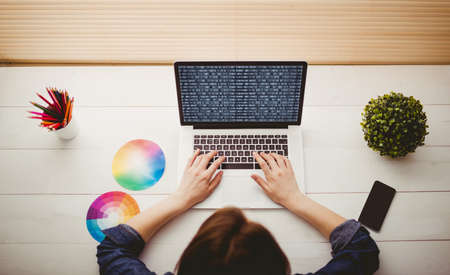 Overhead view of businesswoman using laptop at her deskの写真素材