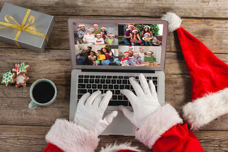 Santa claus on christmas laptop video call with diverse group of friends. christmas, festivity and...