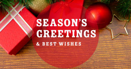 Composition of season's greetings text over christmas decorations and presents. christmas, winter, tradition and celebration concept digitally generated image.の写真素材