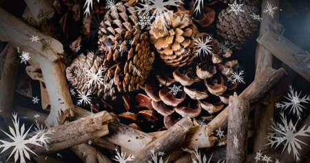 Image of snow falling over christmas decorations on table. christmas, winter, tradition and...