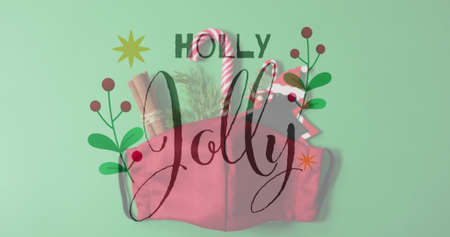 Image of holly jolly text over christmas decorations. christmas, tradition and celebration concept digitally generated image.の写真素材