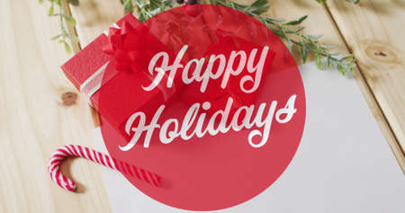 Image of happy holidays text over christmas decorations. christmas, winter, tradition and celebration concept digitally generated image.の写真素材