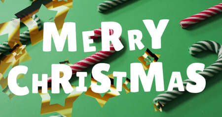 Image of merry christmas greetings text over christmas candy canes decorations. christmas, tradition...