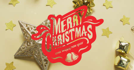 Image of merry christmas text over decorations on yellow background. christmas, tradition and celebration concept digitally generated image.の写真素材