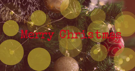 Image of merry christmas text over spots of lights on christmas tree. christmas, tradition and...