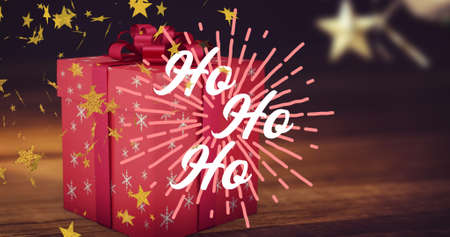 Image of ho ho ho text in white, with gold stars, over christmas present and decorations. christmas,...