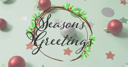 Image of seasons greetings text over christmas decorations. christmas, winter, tradition and celebration concept digitally generated image.の写真素材