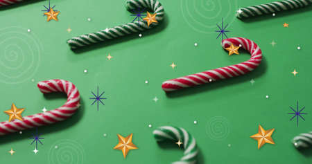 Image of stars over christmas candy canes. christmas, winter, tradition and celebration concept digitally generated image.の写真素材