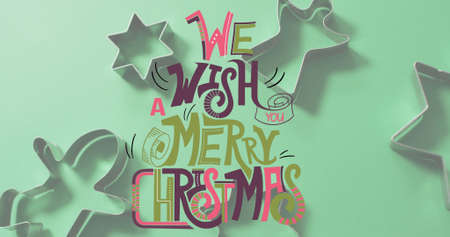 Image of merry christmas text over cookie cutters. christmas, winter, tradition and celebration concept digitally generated image.の写真素材
