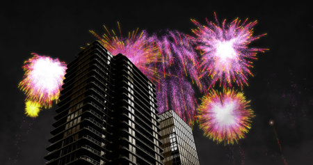 Image of colourful christmas and new year fireworks exploding over tower blocks in night sky. christmas, new year, celebration, party and tradition concept digitally generated image.の写真素材