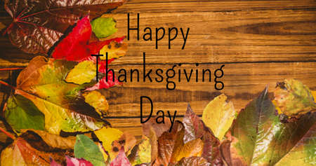 Digital composite image of happy thanksgiving day text and autumn leaves with copy space on table. thanksgiving celebration, nature and autumn concept.の写真素材