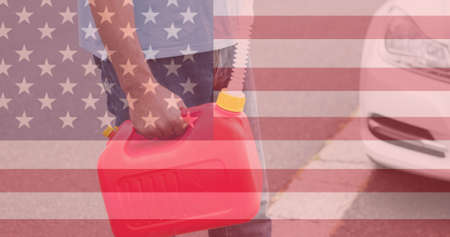 Double exposure of american flag over man carrying petrol gallon on street. digital composite, identity and lifestyle.の写真素材