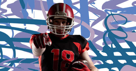 Determined male american football player with ball pointing against abstract background. sport, competition and bowl game.の写真素材