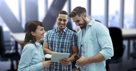 Digital composite image of smiling young business colleagues discussing over digital tablet....