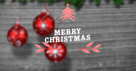 Overhead view of merry christmas text over red baubles on wooden table. digital composite of celebration, decoration and culture.の写真素材