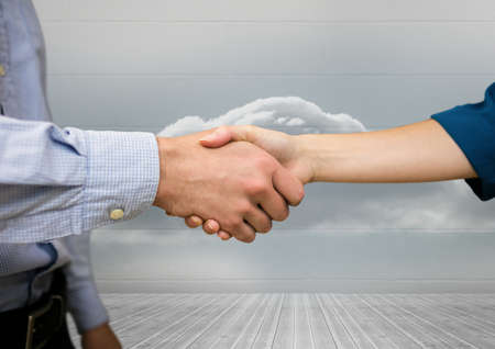 Mid section of businessman and businesswoman shaking hands against clouds in the sky. global business and partnership conceptの写真素材