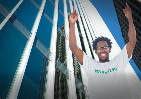 Composite image of afican american male volunteer celebrating against tall buildings in background. social activity conceptの写真素材