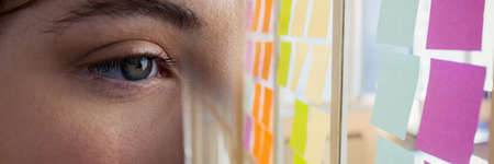 Composite image of close up of a female eye and memo notes at office. business and biometric...