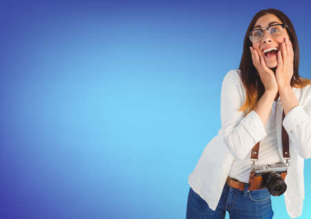Caucasian female photographer with digital camera against copy space on blue gradient background. creative business and photography conceptの写真素材
