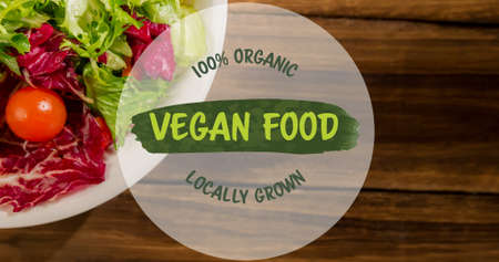 Overhead view of 100 percent organic locally grown vegan food over fresh salad on table. digital composite of healthy food and sign, unaltered.の写真素材