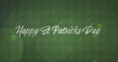 Image of the words Happy St. Patricks Day written in white letters, with multiple green shamrock clover leaves dropping on green shamrock patterned background. Celebration of Irish culture concept digitally generated image.の写真素材