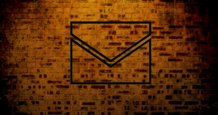 Image of glowing neon envelope icon on brick wall. social media and communication concept digitally generated image.の写真素材