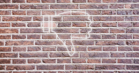 Image of glowing neon thumb down icon on brick wall. social media and communication concept digitally generated image.の写真素材