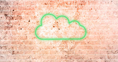 Image of glowing neon cloud icon on brick wall. social media and communication concept digitally...