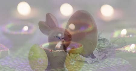 Image of eggs and lights falling over bunny. easter seasonal celebration and tradition digitally generated image.の写真素材