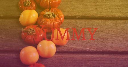 Image of yummy text over vegetables. national vegetarian week and celebration concept digitally...