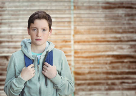 Portrait of caucasian boy against against copy space on textured wooden background. school and...