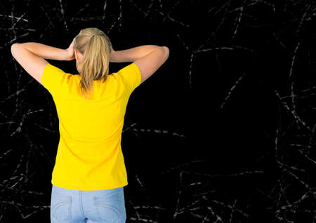Rear view of woman holding her head against copy space on grunge black background. people and emotions conceptの写真素材