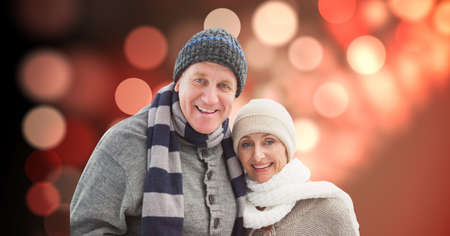 Portrait of caucasian senior couple smiling against spots of light on red background. retirement and...