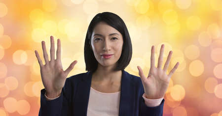 Portrait of asian businesswoman touching invisible screen against spots of light in background. business and technology conceptの写真素材