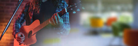 Blurred effect with copy space against mid section of male artist playing guitar. music festival and concert conceptの写真素材