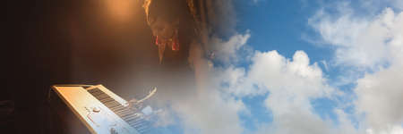 Blue sky with copy space against mid section of african american female artist playing piano. music...